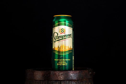 Can of Staropramen beer on beer barrel with dark background. Illustrative editorial photo shot in Bucharest, Romania, 2021