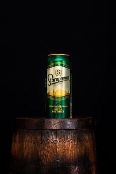 Can of Staropramen beer on beer barrel with dark background. Illustrative editorial photo shot in Bucharest, Romania, 2021