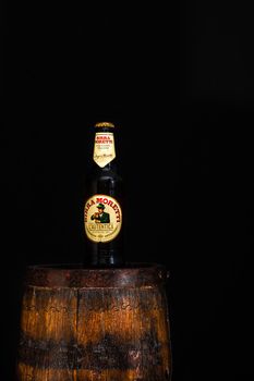 Bottle of Birra Moretti beer on wooden barrel with dark background. Illustrative editorial photo Bucharest, Romania, 2021