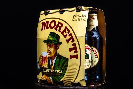 6 pack of Birra Moretti beer on wooden barrel with dark background. Illustrative editorial photo Bucharest, Romania, 2021