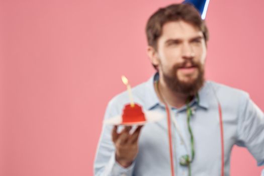 Birthday of a man with a cake and with a candle on a pink background. High quality photo