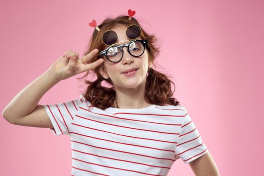 Fashionable girl with clothespins in the form of hearts on her head and glasses on her face. High quality photo
