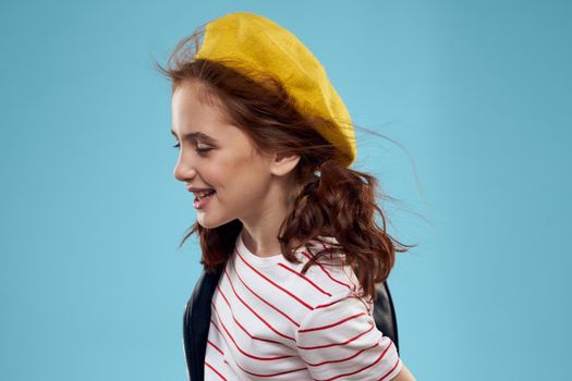 Fashionable girl in a black jacket with a yellow ticket striped T-shirt blue background. High quality photo