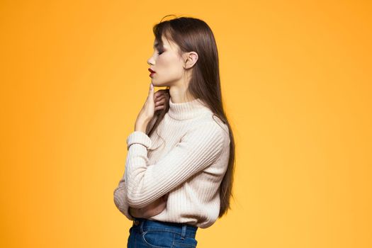 Cute brunette makeup red lips fashionable clothes yellow background. High quality photo