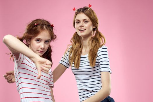funny girlfriends with clothespins hair on a pink background sisters. High quality photo