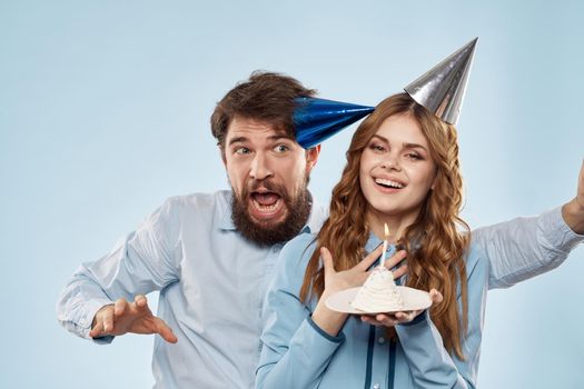 Birthday corporate young man and woman with cake on isolated background disco party. High quality photo