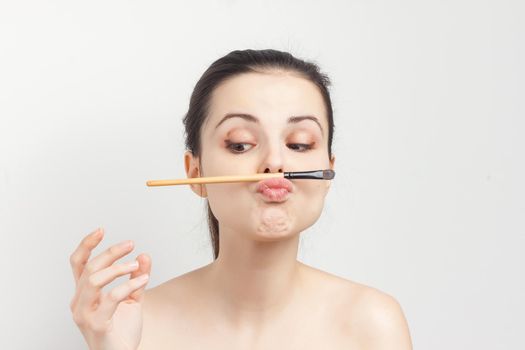 emotional brunette with bare shoulders skin care cream cosmetics hygiene. High quality photo