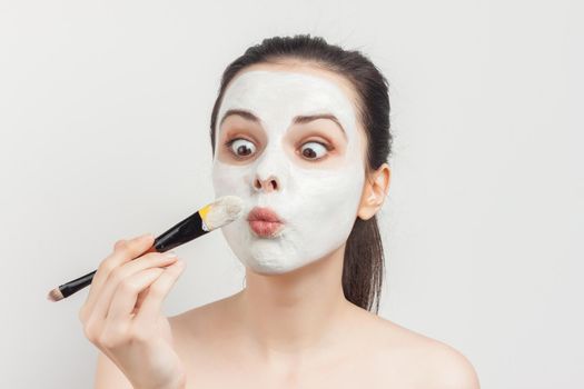 emotional brunette with bare shoulders skin care cream cosmetics hygiene. High quality photo