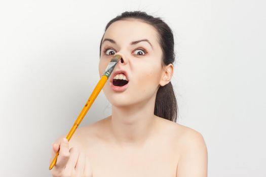 emotional brunette with bare shoulders skin care cream cosmetics hygiene. High quality photo