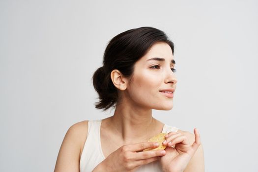 Beautiful brunette holding a sponge in her hands clean health skin close-up. High quality photo