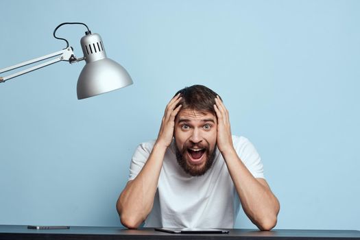 A man in a white T-shirt at his desk communication work Professional. High quality photo