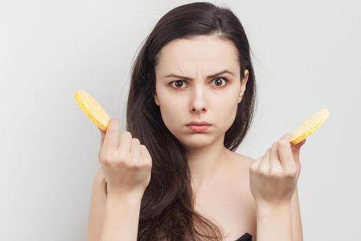 pretty brunette with bare shoulders sponge in hand grooming cropped view. High quality photo