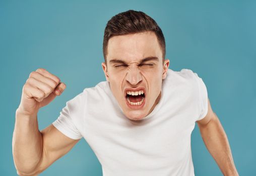 crazy man shouts on blue background with java hands in fist. High quality photo