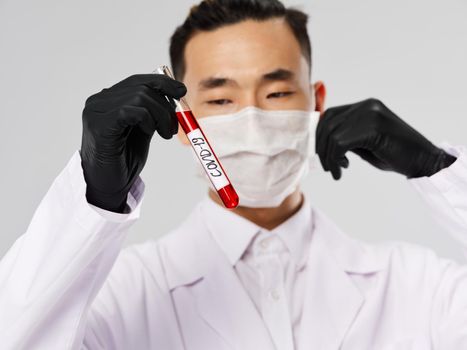 Male laboratory assistant medical mask black gloves blood test research. High quality photo