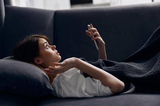 emotional woman on sofa with mobile phone and soft pillow interior. High quality photo