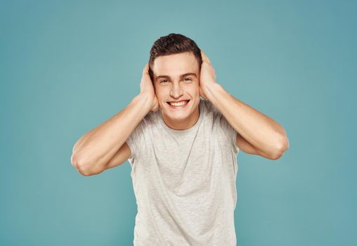 Cheerful man in T-shirt emotions gestures with hands blue background. High quality photo
