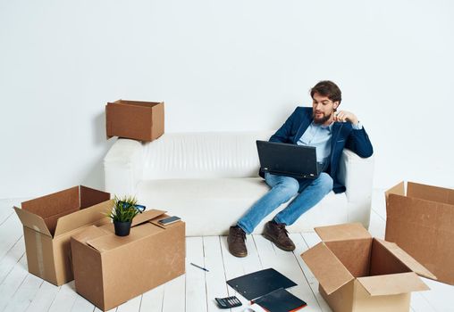 Man sitting on couch boxes with things new place of work office professional. High quality photo