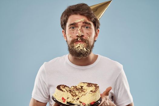 Bearded man in a holiday cap Birthday cake emotions. High quality photo