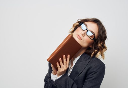 Business woman in a classic suit with a book in her hands and glasses on her face. High quality photo