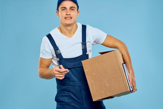 Man in uniform box in hands loading delivery blue background. High quality photo