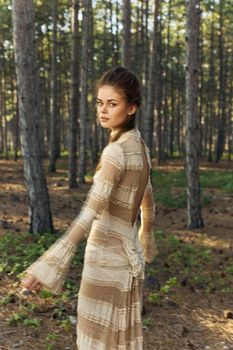 Woman in a coniferous forest in a dress in the fall in nature. High quality photo