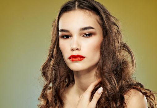 Woman on a dim background with long hair and red lips model makeup. High quality photo