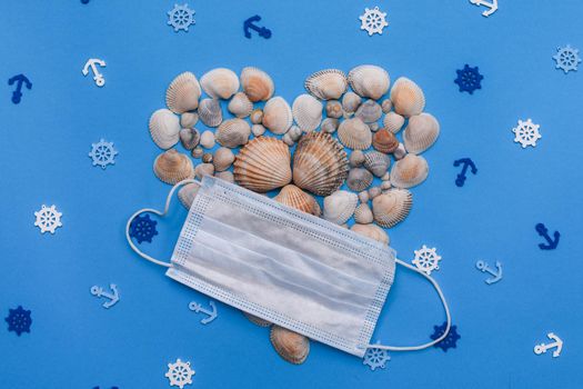 Heart-shaped shells with a medical mask on a blue background. Marine theme. Rest, summer. Anchors and sea rudders. layout, 