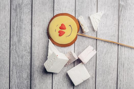 gingerbread in the form of a smiley on a stick marmalade sweets dessert enjoyment wooden background. High quality photo