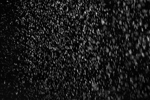 Rain on black. Abstract splashes of water on a black background for screen blending mode and photo retouching.