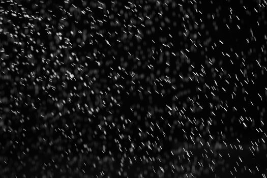 Rain on black. Abstract splashes of water on a black background for screen blending mode and photo retouching.