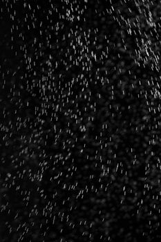 Rain on black. Abstract splashes of water on a black background for screen blending mode and photo retouching.