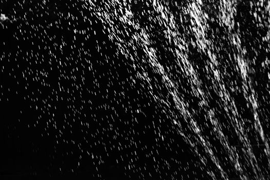Rain on black. Abstract splashes of water on a black background for screen blending mode and photo retouching.