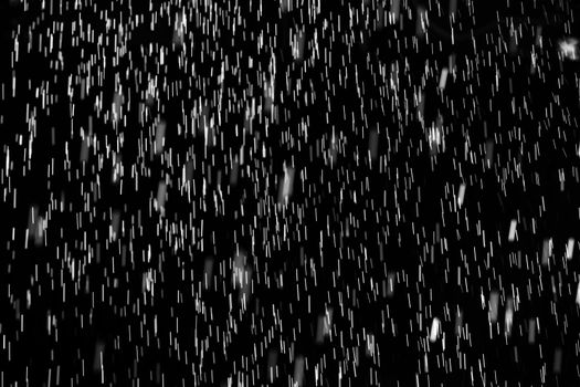 Rain on black. Abstract splashes of water on a black background for screen blending mode and photo retouching.