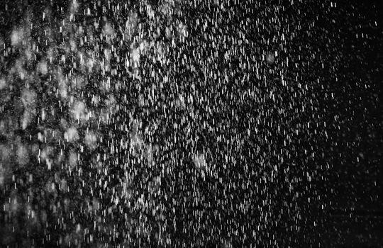 Rain on black. Abstract splashes of water on a black background for screen blending mode and photo retouching.