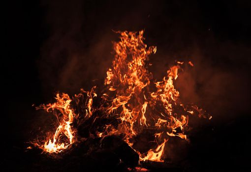 Flames of bonfire at night. Fire flames on a black background