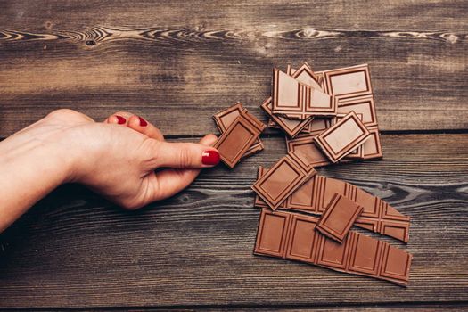 milk chocolate cubes on a wooden table dessert bar. High quality photo