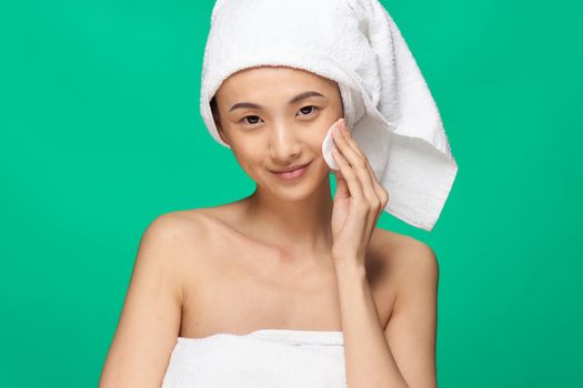 pretty woman naked shoulders clean skin towel on head green background. High quality photo