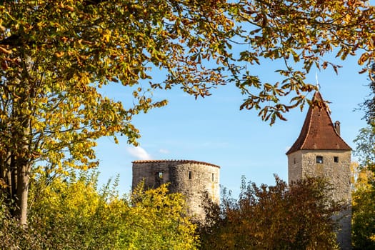 Autumn landscape with multicolored trees and city wall with tower in Berching, Bavaria on a sunny day