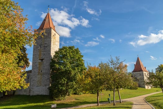 Autumn landscape with multicolored trees and city wall with tower in Berching, Bavaria on a sunny day