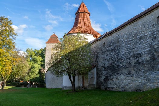 Autumn landscape with multicolored trees and city wall with tower in Berching, Bavaria on a sunny day