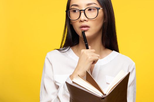 woman of asian appearance with notepad in hands executive office manager isolated background. High quality photo
