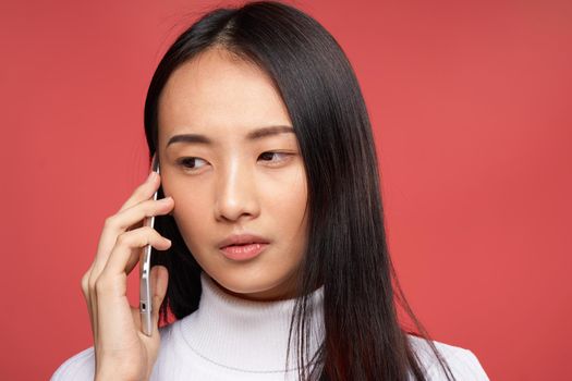 pretty brunette talking on the phone technology close-up red background. High quality photo