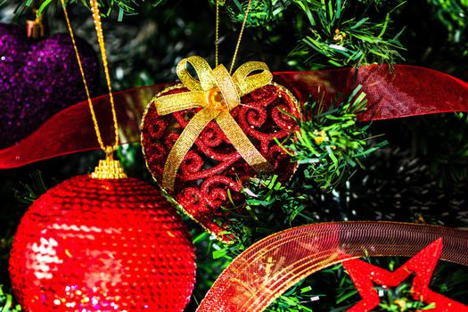 Christmas hanging decorations on fir tree. Decorated Christmas tree. Fir branch with Christmas baubles decorations.