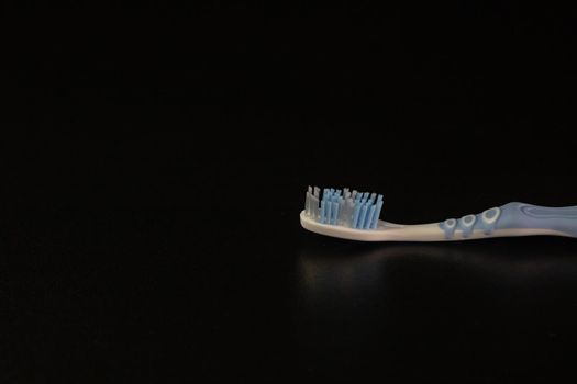 Selective focus on toothbrush isolated on black background.