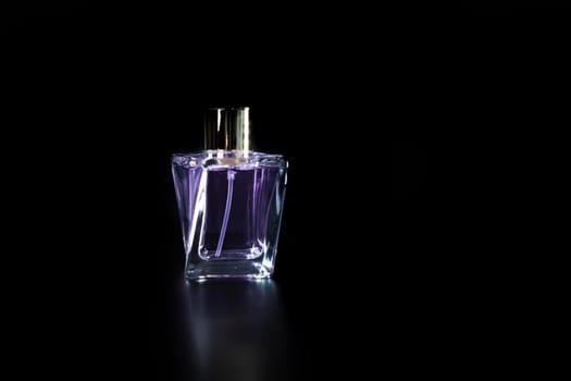 Elegant perfume bottle isolated on black background with copy space.