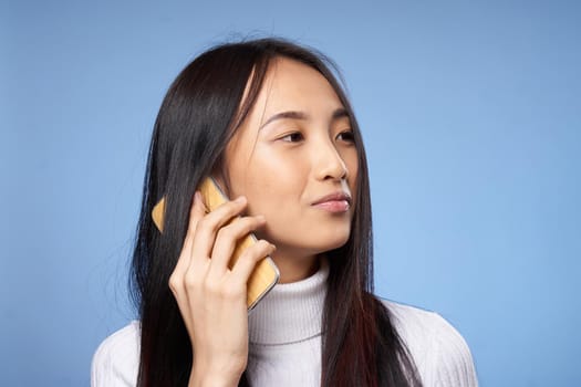 woman asian appearance phone communication technology lifestyle blue background. High quality photo