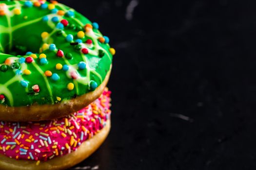 Glazed donuts with sprinkles isolated. Close up of colorful donuts.