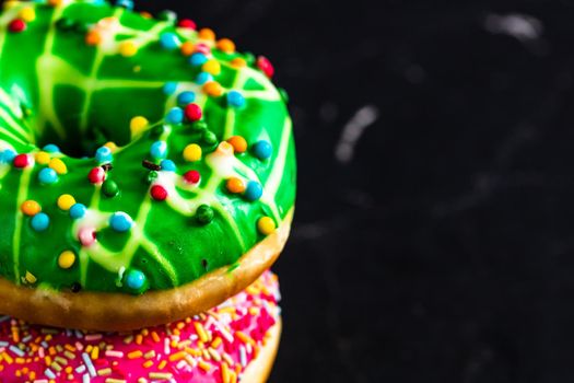 Glazed donuts with sprinkles isolated. Close up of colorful donuts.