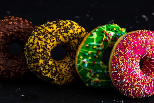 Glazed donuts with sprinkles isolated. Close up of colorful donuts.