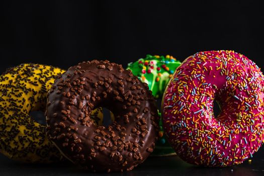 Glazed donuts with sprinkles isolated. Close up of colorful donuts.